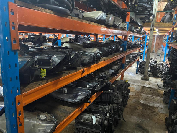 Shelving unit with VW and Audi headlights in a warehouse setting